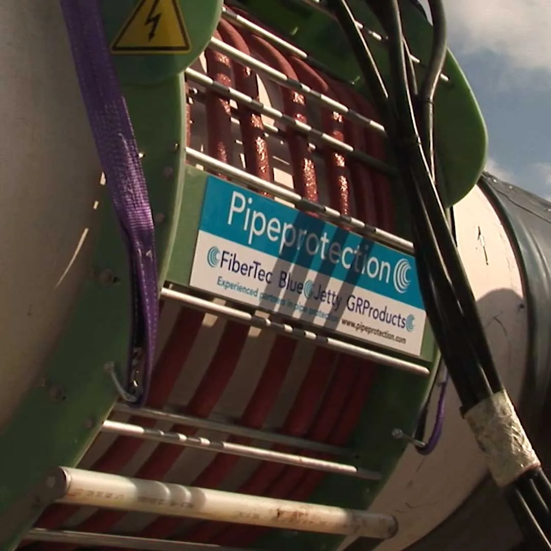 Equipment reel on site carrying the Pipeprotection sign with the FiberTec, Blue Jetty and GRProducts names
