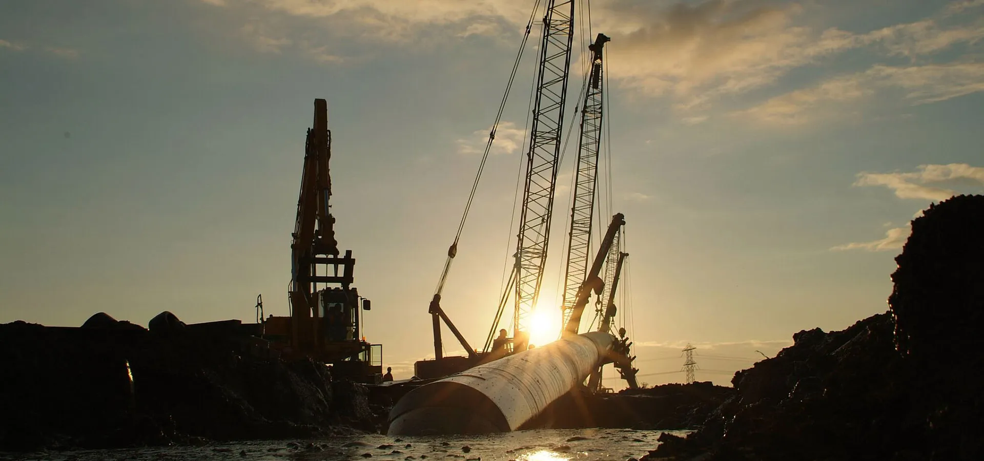 Drilling rig and pipe string at an HDD site at sunset