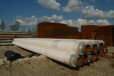 Stack of insulated pipes with laminate finish on a storage yard
